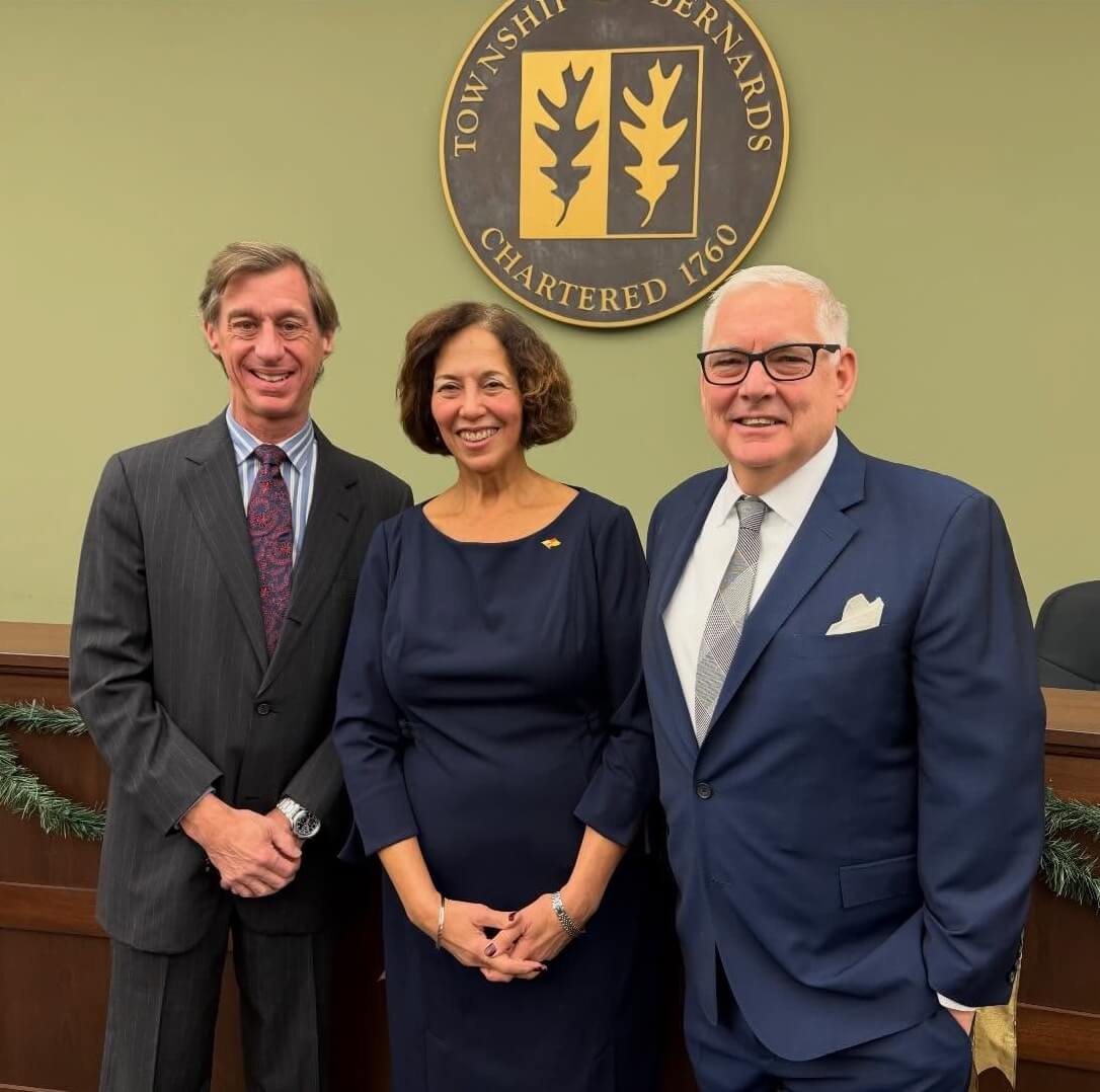Brett Hodges, Ana McCarthy and John Tompkins stand in front of the Bernards Township seal.